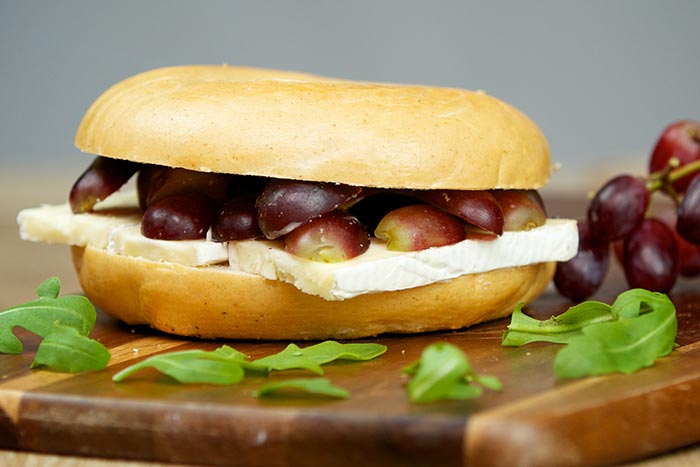 Bagel with brie cheese and grapes on board