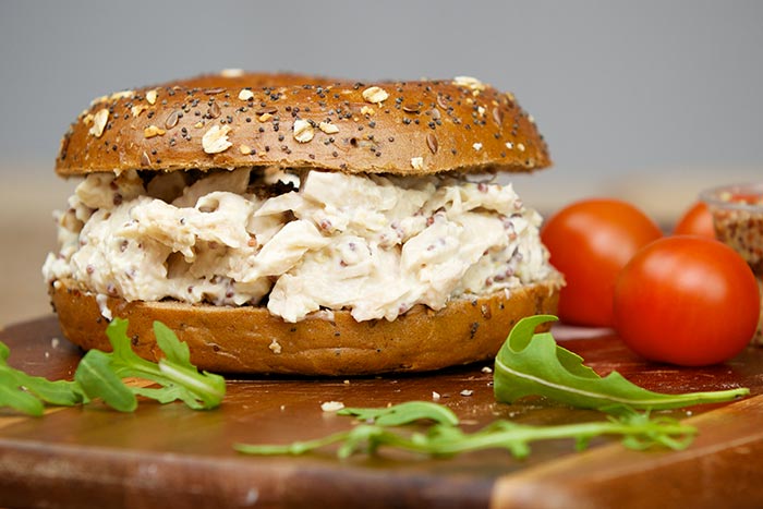 Bagel with chicken salad, tomatoes, and arugula