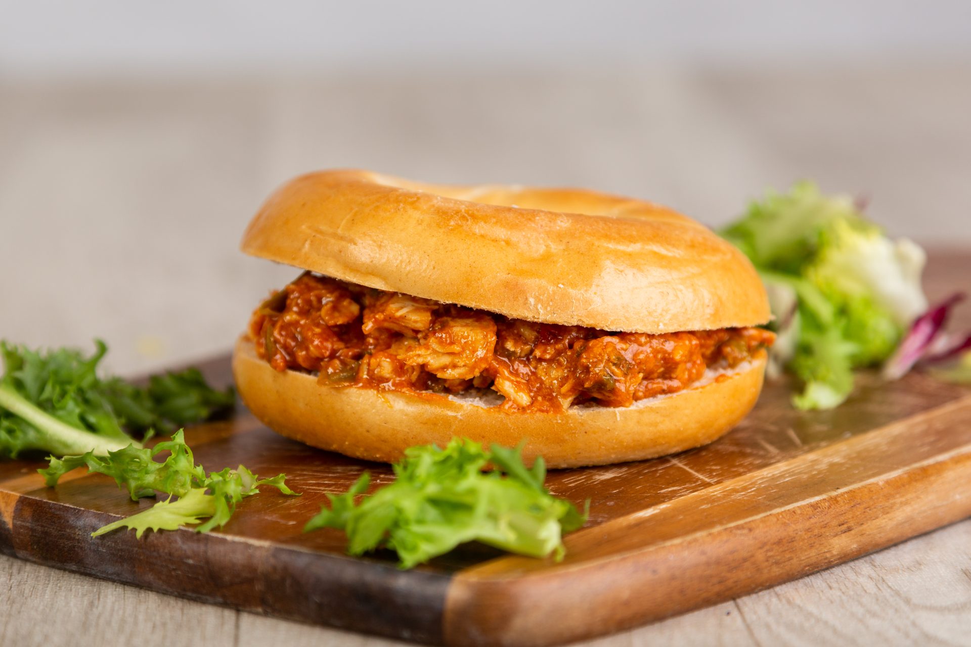 Bagel filled with shredded barbecue chicken and salad