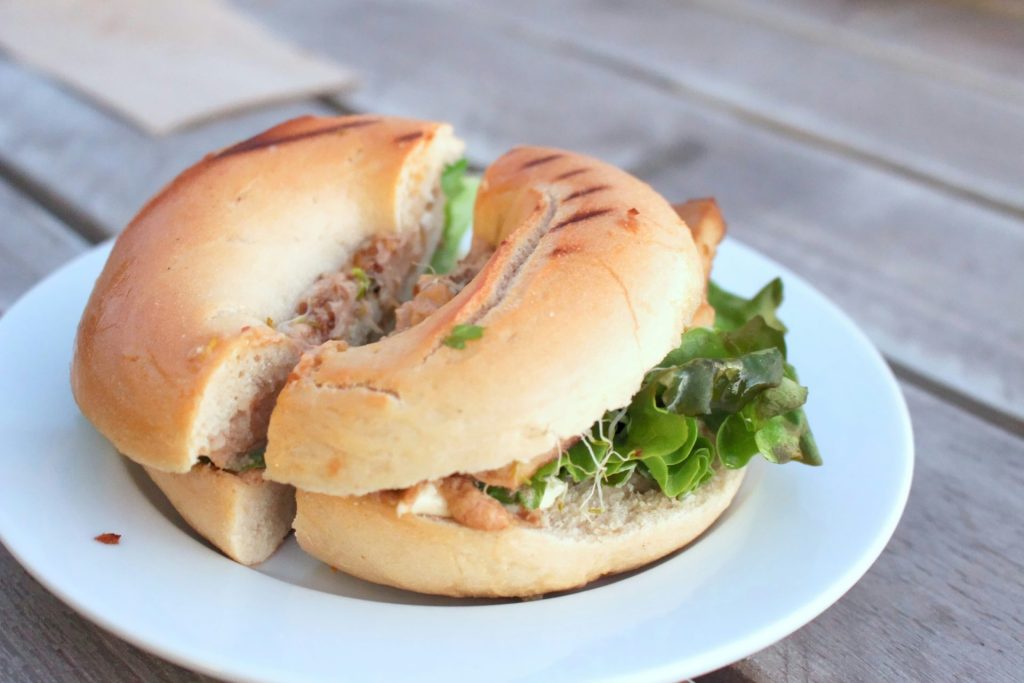 Bagel with tuna salad and fresh lettuce on a plate